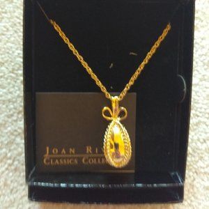 Gold tone polished caged egg necklace